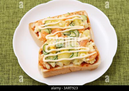 Kartoffel- und Gemüsesalat Mayonnaise serviert auf normalem Brot und gebacken auf einem Teller Stockfoto