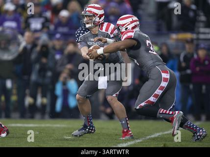 16. November 2013: Evanston, Illinois, Vereinigte Staaten von Amerika - 16. November 2013: Der nordwestliche Quarterback Trevor Siemian (13) übergibt den Ball an den Northwestern Running Back Warren Long (34) während der NCAA Football-Action zwischen den Michigan Wolverines und den Northwestern Wildcats im Ryan Field in Evanston, Illinois. Michigan besiegte Northwestern 27-19 in dreifacher Überstunde. (Bild: © John Mersits/Cal Sport Media/ZUMAPRESS.com) Stockfoto