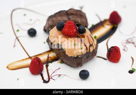 Dessert mit Sahne, Beeren und Schokoladensauce auf weißem Hintergrund Stockfoto