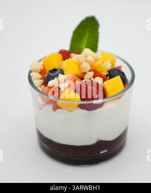 Mangojoghurt mit frischer Mango und Heidelbeere auf weißem Hintergrund Stockfoto
