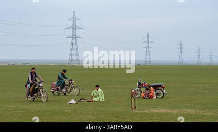 Zufällige einheimische Männer spielen Cricket Stockfoto