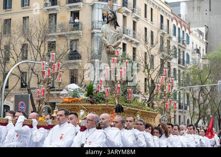 Madrid, Spanien. April 2025. Costaleros tragen während einer feierlichen Osterprozession einen kunstvollen Wagen der Karwoche mit einer Statue Jesu Christi. Die Karwochenprozession in Madrid ist eine tief verwurzelte katholische Tradition, die in der Woche vor Ostern stattfindet. Mit feierlichen Paraden mit religiösen Wagen, traditioneller Musik und Teilnehmern in Bußgewändern spiegelt die Veranstaltung das reiche spirituelle Erbe Spaniens wider und zieht jedes Jahr Tausende von Zuschauern an. Quelle: SOPA Images Limited/Alamy Live News Stockfoto