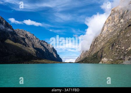 Ein atemberaubender türkisfarbener See reflektiert den blauen Himmel, eingebettet zwischen hoch aufragenden Bergen. Die friedliche Landschaft ist Teil der berühmten Laguna 69 Trek in Hu Stockfoto