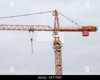 Turmkran Gegen Den Bewölkten Himmel. Industrielle Baumaschinen, die perfekt für Stadtentwicklungsprojekte geeignet sind. Stockfoto