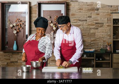 Küchenchefs bereiten Zutaten für den Kochkurs in der Restaurantküche vor Stockfoto
