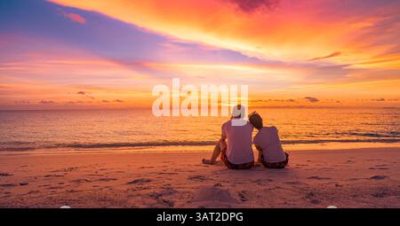 Liebe Paare sitzen zusammen Sonnenuntergang Himmel Wolken genießen friedliche Sommerlandschaft ruhige Wellen Strand Romantik. Panoramafenster mit Lifestyle-Design Stockfoto