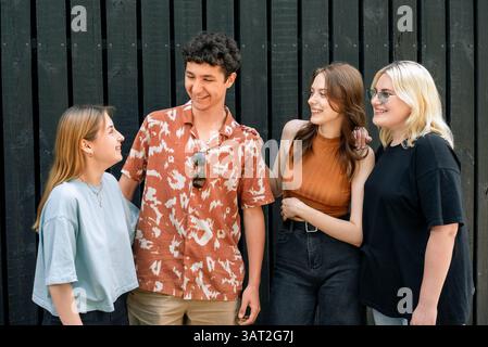 Gruppe fröhlicher Freunde, die sich draußen unterhalten Stockfoto