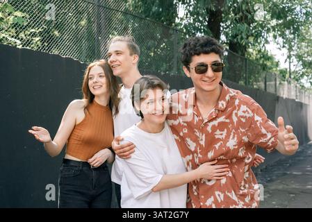 Glückliche junge Freunde, die sich draußen im Sonnenlicht unterhalten Stockfoto