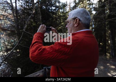 Senior Mann, der im Wald in der Nähe des Lago di Antholva fotografiert Stockfoto