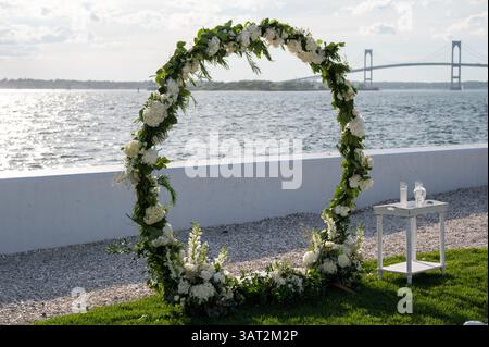 Blumenhochzeitbogen am Wasser mit Blick auf die Brücke Stockfoto