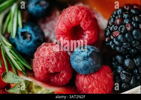 Nahaufnahme von frischen Beeren, Rosmarin, Oliven und Honig-Dip. Stockfoto
