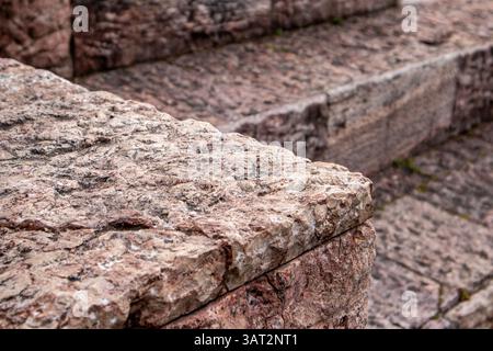 Die Nahaufnahme der strukturierten Steinstufen zeigt die komplizierten Details der rauen verwitterten Oberfläche und fängt die Geschichte ein. Die raue Gesteinsstruktur alter Bauten. Stockfoto