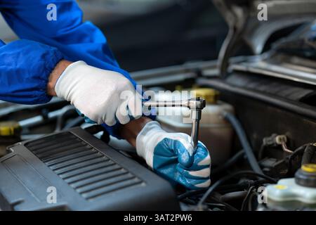 Zugeschnittene Aufnahme eines professionellen Mechanikers, der am Motor des Autos in der Garage arbeitet. Autoreparaturservice. Das Konzept der Überprüfung der Bereitschaft von Stockfoto