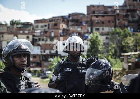 21. Juli 2013 - Caracas, Miranda, Venezuela - Mitglieder der Nationalgarde bewachen das Anwesen, nachdem sie angekommen sind, um etwa 200 Menschen zu entfernen, die das Land besetzt hatten, in der Hoffnung, darauf Häuser zu bauen. Die sozialistische Regierung sagt, dass das 10 Hektar große Grundstück der Standort einer Reihe von Wohnblocks für öffentliche Wohnungen sein wird, ein Projekt, das vor vier Jahren initiiert wurde, aber noch nicht begonnen hat. Laut einem Bewohner wollen wir nur, dass die Regierung anfängt zu bauen oder uns das Land zu geben, und wir werden es selbst tun. (Kreditbild: © Charles Mostoller/ZUMAPRESS.com) Stockfoto
