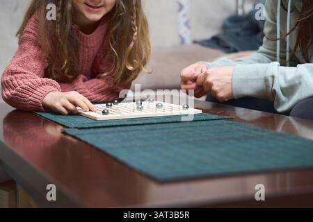 Kind und Erwachsener genießen gemeinsam ein Strategiespiel, das die Bindung der Familie und die kognitiven Fähigkeiten fördert Stockfoto