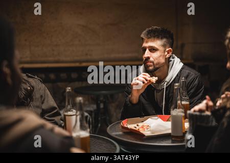 Eine Gruppe von Freunden genießt spätabendliche Snacks und Gespräche in einem gemütlichen Restaurant Stockfoto