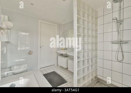 Ein elegantes und modernes Bad mit modernen Fliesen, Duschkabine und minimalistischen Armaturen für eine saubere Ästhetik. Stockfoto