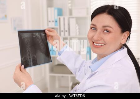 Lächelnder Arzt mit Hals-MRT in der Klinik Stockfoto