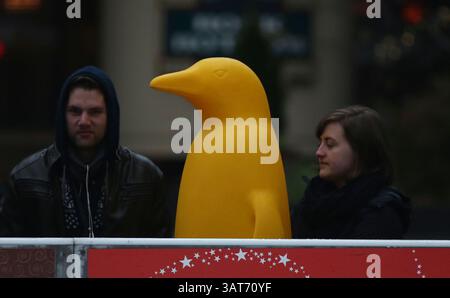 November 2013 - Cincinnati, Ohio, USA S - zwei Einheimische stehen mit einem großen Pinguin, während sie das Truthahn Bowling-Event auf der Eislaufbahn am Fountain Square in der Innenstadt von Cincinnati, Ohio, beobachten. Am 26. November 2013 im Rahmen des jährlichen Events für die Freestore Foodbank. (Bild: © Ernest Coleman/ZUMAPRESS.com) Stockfoto