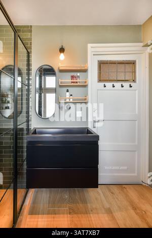 Ein modernes Badezimmer mit eleganten Armaturen, eleganten Schränken und sanfter Beleuchtung sorgt für eine entspannte Atmosphäre. Ideal für modernes Wohnen. Stockfoto