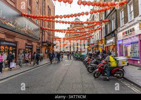 London, Großbritannien – 19. September 2024: Gerrard Street in Londons Chinatown füllen rote Laternen und geschäftige Geschäfte die lebhafte Szene. Laternen über dem Kopf und Roller Stockfoto