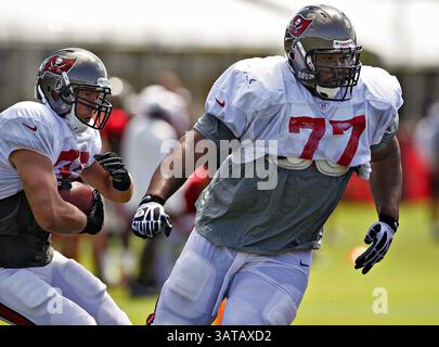 10. August 2013 - Tampa, FL, USA - der Tampa Bay Buccaneers-Wachmann Carl Nicks (77) schlägt eine Lücke für den Rücklauf Brian Leonard (30) während des Buccaneers-Trainingslagers an One Buc Place in Tampa, Florida, Samstag, 10. August 2013. (Bild: © Daniel Wallace/MCT/ZUMAPRESS.com) Stockfoto