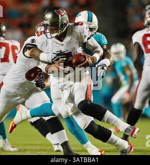 24. August 2013 - Miami, FL, USA - Tampa Bay Buccaneers Quarterback Josh Freeman (5) wird vom Miami Dolphins Linebacker Jonathan Freeny (56) wegen eines Verlustes von 10 Yards im Sun Life Stadium in Miami, Florida, am Samstag, den 24. August 2013 geplündert. Die Buccaneers besiegten die Delfine mit 17:16. (Bild: © Daniel Wallace/MCT/ZUMAPRESS.com) Stockfoto