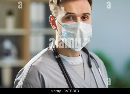 Nahaufnahme-Porträt eines jungen Arztes mit Arbeitsuniform und Operationsmaske Stockfoto