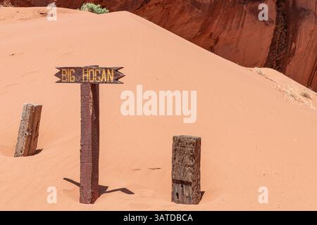 Schild mit dem Amphitheater Big Hogan mit einem Naturbogen im Monument Valley, Arizona, USA Stockfoto