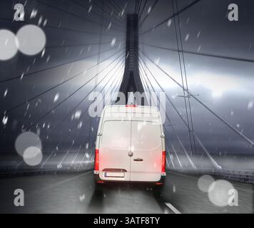 Ein Express-Kurierdienst bei schlechtem Winterwetter nachts auf der Autobahn mit roten Rücklichtern und Schneefall. Stockfoto