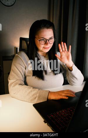 Lächelnde freundliche Freiberuflerin, die Online-Konferenzgespräche mit einem Kunden zu Hause führt. Remote-Job-Konzept Stockfoto