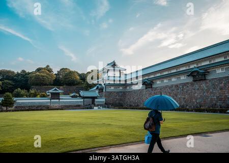 Ruhige Aussicht auf eine traditionelle japanische Burgmauer mit Ziegeldächern, Steinbasis und offenem Himmel, mit historischer Architektur und friedlicher Landschaft. Stockfoto