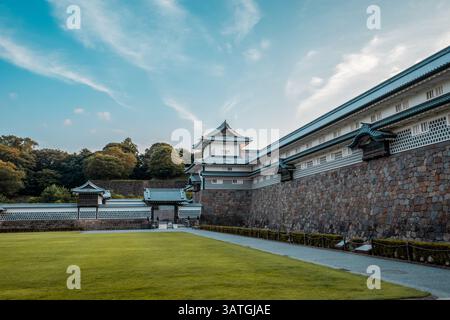 Ruhige Aussicht auf eine traditionelle japanische Burgmauer mit Ziegeldächern, Steinbasis und offenem Himmel, mit historischer Architektur und friedlicher Landschaft. Stockfoto