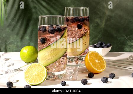 Modernes Stillleben mit Getränken. Diät veganer Cocktail mit Gurke, Zitrone, Limette, Heidelbeere und Chiasamen, Detox Diät und Gewichtsreduktion Konzept, gesund l Stockfoto