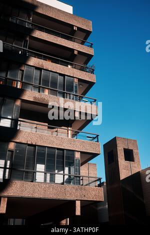 London, Großbritannien - 28. September 2024: Brutalistische Balkone des Barbican Estate mit Schattenlinien und tiefblauem Himmel in der City of London. Stockfoto