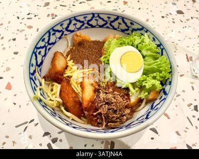 Köstliche Schüssel mit asiatischen Nudeln, Sojasprossen und Ei mit einer scharfen Sauce Stockfoto