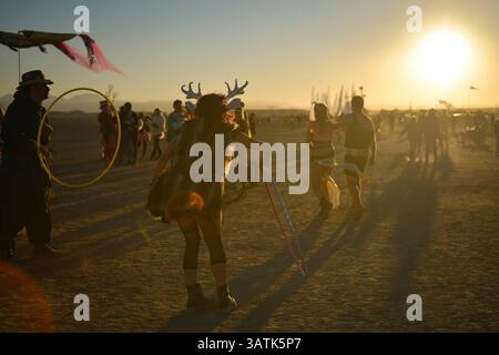 30. April 2016: Tankwa Town, Karoo-Wüste, Südafrika: Eine Frau, die mit Hirschschädel und Geweih gekleidet ist, steht mit einem Hula-Hoop, während die Sonne an einem anderen Tag von AfrikaBurn in der Karoo-Wüste, Südafrika, am 30. April 2016 untergeht. AfrikaBurn, der kleinere Cousin von Burning man, befindet sich jetzt im zehnten Jahr und will kreative aus aller Welt zusammenbringen, um Kunst zu schaffen, in einer nicht-monetären Wirtschaft zu existieren und eine alternative Lebensform zu feiern. (Bild: © Tobin Jones/ZUMA Wire/ZUMAPRESS.com) Stockfoto