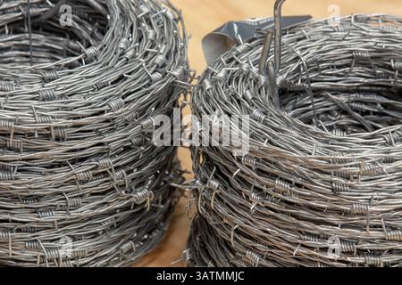 Nahaufnahme einer Stapelrolle aus glänzendem neuem Stacheldraht. Stockfoto