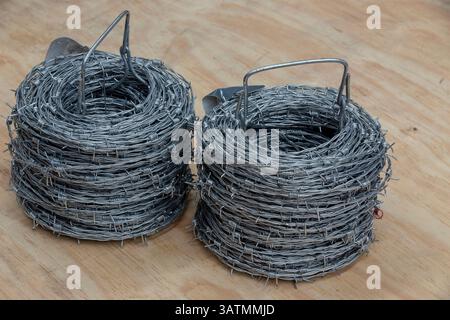 Nahaufnahme einer Stapelrolle aus glänzendem neuem Stacheldraht. Stockfoto