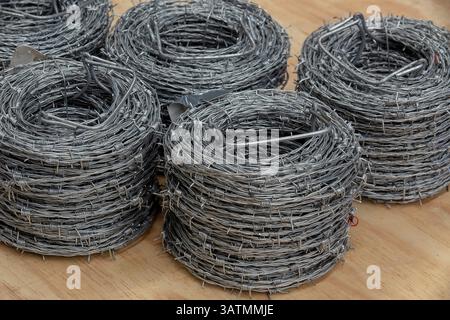 Nahaufnahme einer Stapelrolle aus glänzendem neuem Stacheldraht. Stockfoto
