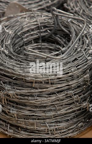 Nahaufnahme einer Stapelrolle aus glänzendem neuem Stacheldraht. Stockfoto