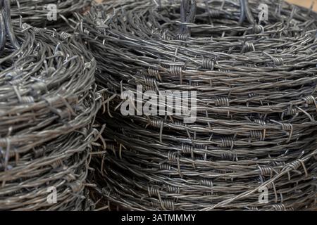 Nahaufnahme einer Stapelrolle aus glänzendem neuem Stacheldraht. Stockfoto