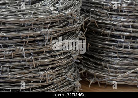 Nahaufnahme einer Stapelrolle aus glänzendem neuem Stacheldraht. Stockfoto