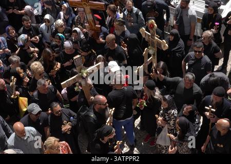 JERUSALEM – 18. APRIL: Christlich-orthodoxe Pilger halten Kreuze, während sie die Via Dolorosa in der Altstadt während der Karfreitagsprozession am 18. April 2025 in Jerusalem, Israel, durchlaufen. Christen feiern Karfreitag, um der Kreuzigung Jesu und seinem Tod am Kreuz zu gedenken. Stockfoto