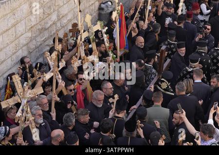 JERUSALEM – 18. APRIL: Mitglieder der griechisch-orthodoxen Kirche tragen ein großes Holzkreuz, während sie während der Karfreitagsprozession am 18. April 2025 in Jerusalem, Israel, die Via Dolorosa in der Altstadt entlang laufen. Christen feiern Karfreitag, um der Kreuzigung Jesu und seinem Tod am Kreuz zu gedenken. Stockfoto