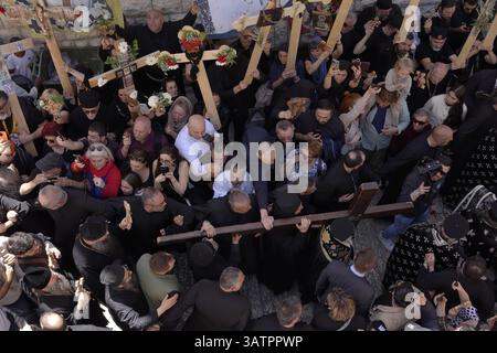 JERUSALEM – 18. APRIL: Mitglieder der griechisch-orthodoxen Kirche tragen ein großes Holzkreuz, während sie während der Karfreitagsprozession am 18. April 2025 in Jerusalem, Israel, die Via Dolorosa in der Altstadt entlang laufen. Christen feiern Karfreitag, um der Kreuzigung Jesu und seinem Tod am Kreuz zu gedenken. Stockfoto