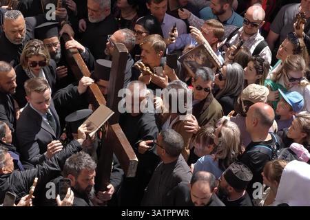 JERUSALEM – 18. APRIL: Christlich-orthodoxe Pilger halten Kreuze, während sie die Via Dolorosa in der Altstadt während der Karfreitagsprozession am 18. April 2025 in Jerusalem, Israel, durchlaufen. Christen feiern Karfreitag, um der Kreuzigung Jesu und seinem Tod am Kreuz zu gedenken. Stockfoto