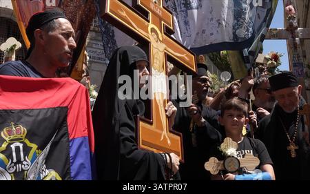 JERUSALEM – 18. APRIL: Christlich-orthodoxe Pilger aus Serbien halten Kreuze und singen während eines Spaziergangs entlang der Via Dolorosa in der Altstadt während der Karfreitagsprozession am 18. April 2025 in Jerusalem, Israel. Christen feiern Karfreitag, um der Kreuzigung Jesu und seinem Tod am Kreuz zu gedenken. Stockfoto