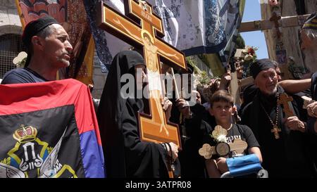JERUSALEM – 18. APRIL: Christlich-orthodoxe Pilger aus Serbien halten Kreuze und singen während eines Spaziergangs entlang der Via Dolorosa in der Altstadt während der Karfreitagsprozession am 18. April 2025 in Jerusalem, Israel. Christen feiern Karfreitag, um der Kreuzigung Jesu und seinem Tod am Kreuz zu gedenken. Stockfoto