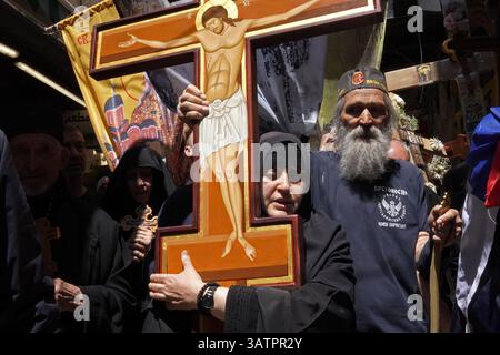 JERUSALEM – 18. APRIL: Christlich-orthodoxe Pilger aus Serbien halten Kreuze und singen während eines Spaziergangs entlang der Via Dolorosa in der Altstadt während der Karfreitagsprozession am 18. April 2025 in Jerusalem, Israel. Christen feiern Karfreitag, um der Kreuzigung Jesu und seinem Tod am Kreuz zu gedenken. Stockfoto